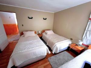 a room with two beds in a room at Cabaña nieve, tinaja y vista al volcan in Curacautín
