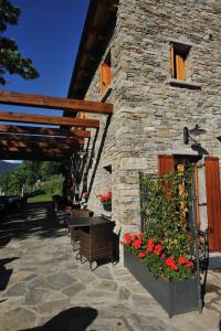a stone building with a table and flowers on it at Agriturismo La Tensa in Domodossola