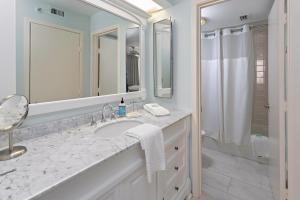 Un baño blanco con lavabo y ducha. en North Breakers #201, en Saint Simons Island 19 fotos más