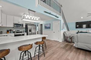 a kitchen and living room with a counter and stools at Sunbeam Sands in Kill Devil Hills