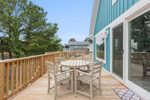 a patio with a table and chairs on a deck at Sunbeam Sands in Kill Devil Hills