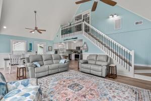 a living room with two couches and a staircase at Sunbeam Sands in Kill Devil Hills +28 photos