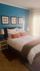a bedroom with a large bed with a blue wall at Casa Clarity - Peaceful 1BR and Office Near Cape Town & Stellenbosch in Brackenfell