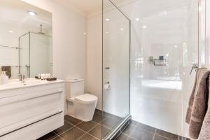een badkamer met toilet en glazen douche bij Sunset Water Premium 2 bedroom in Hamilton Island +25 foto's