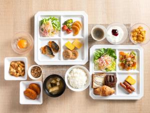 a table with plates of food and bowls of food at Super Hotel Hida Takayama in Takayama