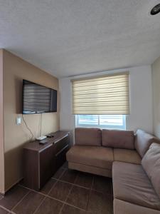 a living room with a couch and two windows at Casa las palmas in Morelia