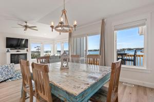 a dining room and living room with a table and chairs at Sunset On The Sound in Kill Devil Hills
