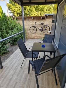 a patio with two chairs and a table and a bike at Apartman27 Palic in Palić