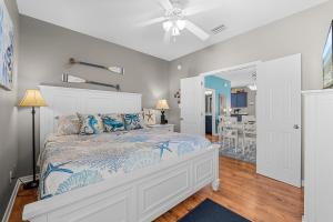 a bedroom with a bed and a ceiling fan at Paradise Found Gulf Shores Beach Pools Dogs in Gulf Shores +49 photos