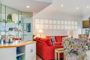 a kitchen and living room with a red couch at Sunset Sanctuary in Nags Head +28 photos