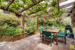 a patio with a wooden table and chairs and a grill at Waitomo Caves Guest Lodge in Waitomo Caves