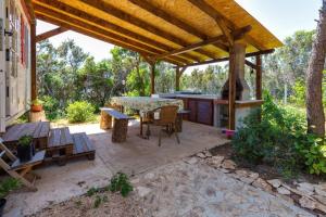 an outdoor patio with a table and a grill at Apartments by the sea Cove Kurila, Losinj - 24571 in Mali Lošinj