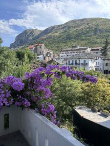 モスタルにあるMONA Historic central apartmentの白い柵に紫色の花束