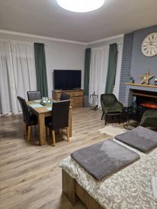a living room with a table and chairs and a television at Apartman277 Palić in Palić