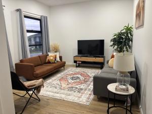 a living room with a couch and a tv at Urban Pause - Doreen in Doreen