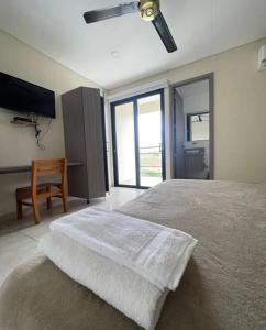a bedroom with a large bed and a chair at Hotel y restaurante la estancia in Estación El Salto