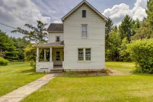 una vieja casa blanca en un campo de hierba en Pet-Friendly Smithmill Retreat with Hunting On-Site!, en Houtzdale