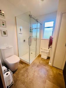 a bathroom with a glass shower and a toilet at Saltwater Studio in Motueka +15 photos