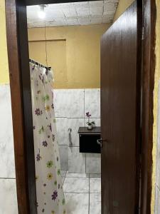 a bathroom with a shower curtain with flowers on it at Kitnet Centro in Santo Antônio do Pinhal +6 photos