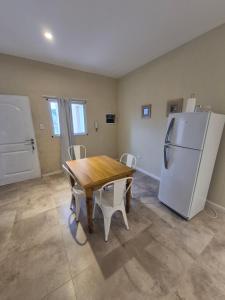 a kitchen with a wooden table and a refrigerator at Pato Overo - Complejo Tres Picos in Sierra de la Ventana