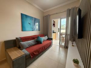 a living room with a couch and a television at Ubatuba- Praia das Toninhas 104. in Ubatuba