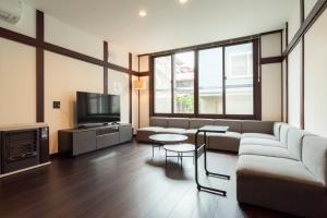 a living room with a couch and a tv at J style villa Sapporo フルリフォーム 長期滞在にもオススメ マーケット近く in Sapporo