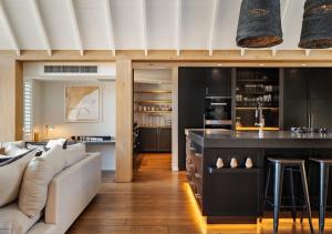 cocina y sala de estar con sofá y bar en Aroha Homestead Luxury Holiday Home by MajorDomo, en Arrowtown