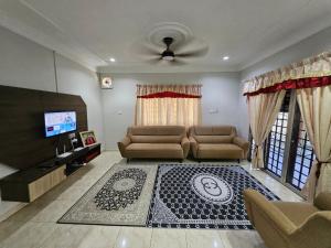 a living room with a couch and a tv at Teratak Abah in Seri Manjung