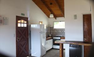 eine Küche mit einem weißen Kühlschrank und einem Herd in der Unterkunft Las Nubes in El Bolsón