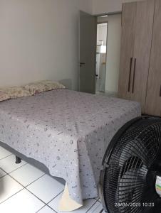 a bedroom with a bed and a fan at Hospedagem da Mag in João Pessoa