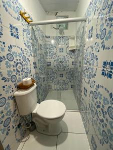 a bathroom with a toilet and blue and white tiles at Chalé Tiririca Surf & Mar in Itacaré +49 photos