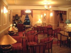 a living room filled with tables and chairs at Ely House Hotel in Wolverhampton