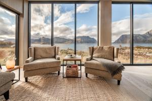 a living room with two chairs and large windows at New lodge at seaside, near Henningsvær Lofoten in Kleppstad