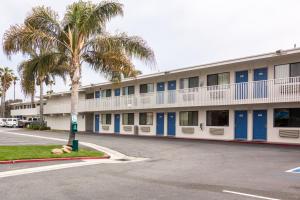 a building with palm trees in front of a street at Motel 6-Ventura, CA - Beach in Ventura