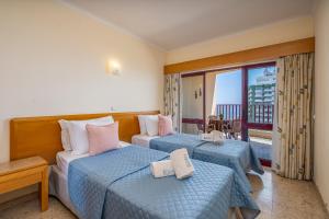 een hotelkamer met twee bedden en een balkon bij Sea Top Flat II in Portimão +31 foto's