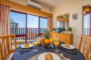 een tafel met eten en sinaasappels erop met een balkon bij Sea Top Flat II in Portimão