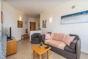 een woonkamer met een bank en een tv bij Sea Top Flat II in Portimão