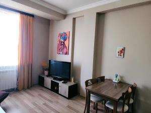 salon ze stołem i telewizorem w obiekcie Cocoa Nook w mieście Tbilisi City