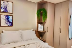a bedroom with a bed and a cabinet at Bem Estar Studio no All Batel in Curitiba