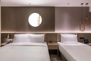 Cama o camas de una habitación en Qingdao Shandong Road Mixc Orange Crystal Hotel