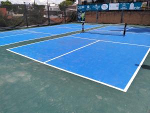 a blue tennis court with a net on it at Hotel Bungalows La Era in Ixtapan de la Sal