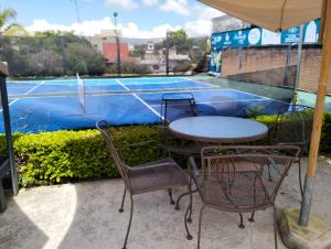 a table and chairs sitting next to a tennis court at Hotel Bungalows La Era in Ixtapan de la Sal
