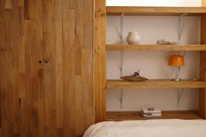 a bedroom with wooden shelves and a bed with a lamp at Stay Hosa in Suwon