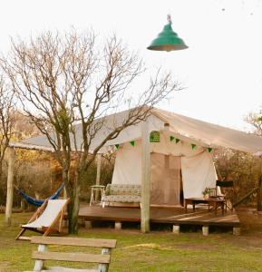 a tent with a bench and a hammock at Glamping Traslasierra Carpa Norte in San Javier