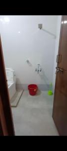 une salle de bain avec un seau rouge et un lavabo dans l'établissement Manan Guest House, à Malpe