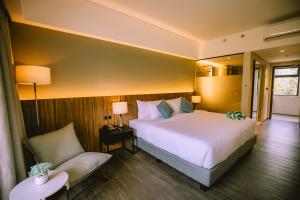 卡瓦延市The Maximilian Hotel的一间带床和椅子的酒店房间