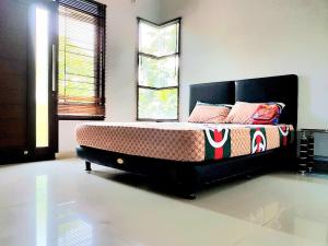 Un dormitorio con una cama en una habitación con ventanas. en Fatih Homestay, en Bandung