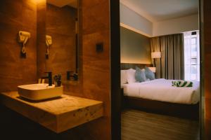 卡瓦延市The Maximilian Hotel的带水槽和床的浴室