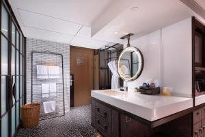 un bagno con lavandino e specchio di Lingshui Xiangshui Bay Summer Surfing Resort a Lingshui