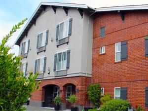 un bâtiment en briques rouges avec des fenêtres à volets bleus dans l'établissement Bel Abri Napa Valley Inn, à Napa